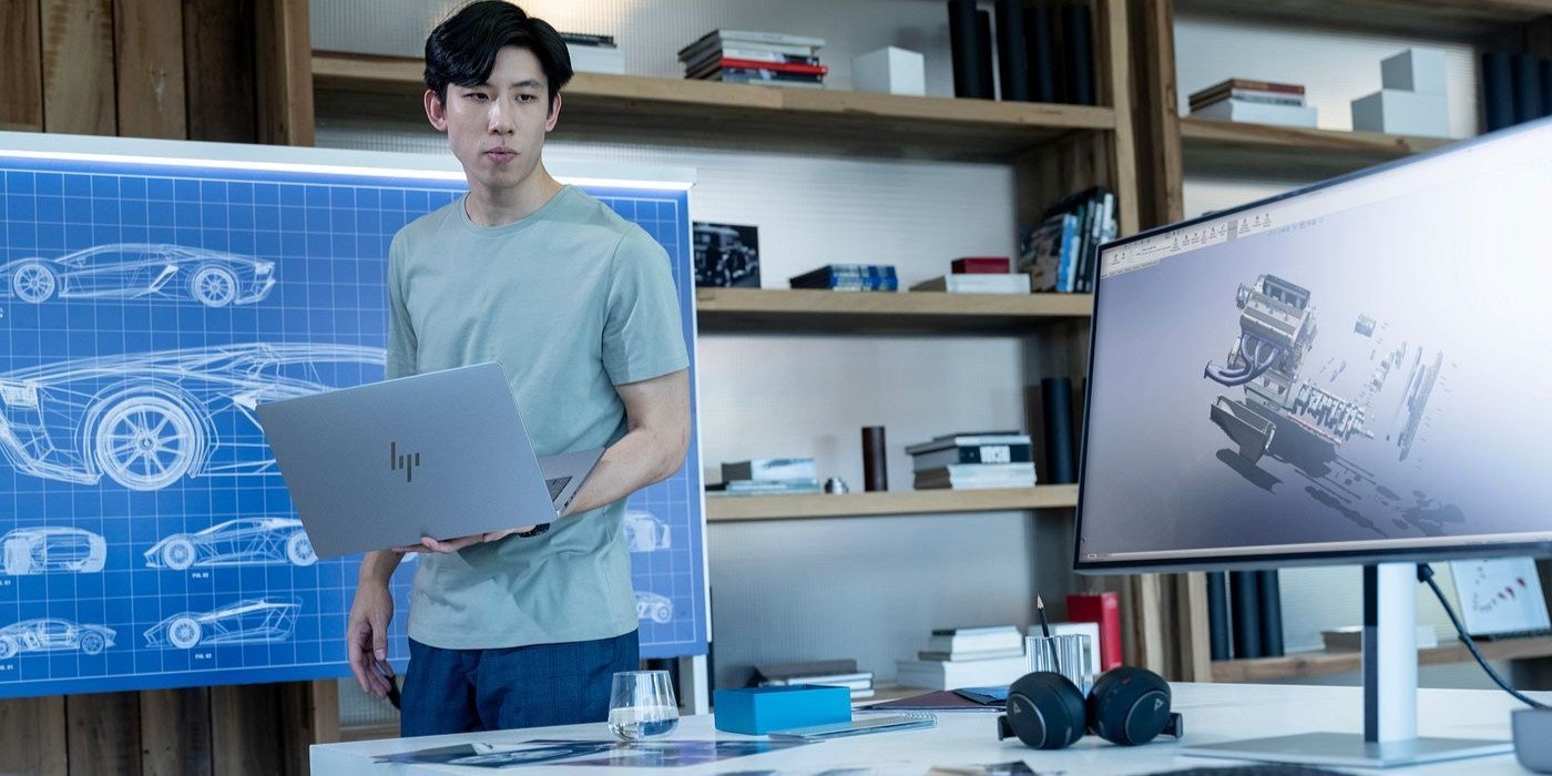 Un ingeniero trabaja en un proyecto de diseño automotriz utilizando una workstation HP y un monitor con software de modelado 3D, en un entorno moderno y profesional.