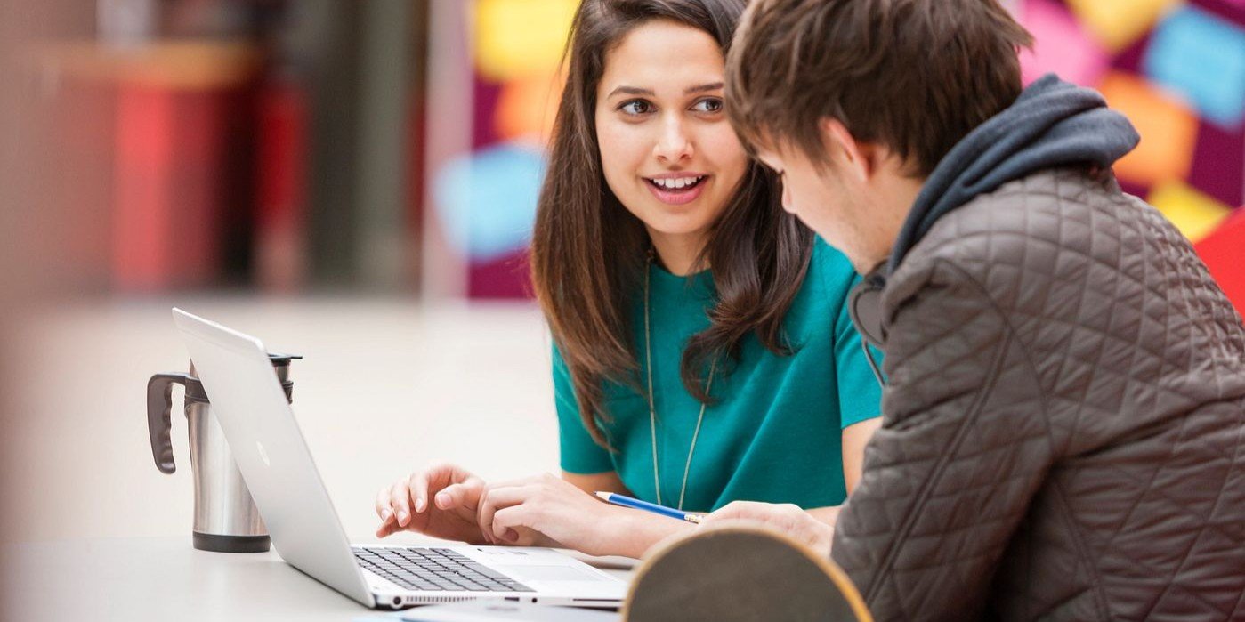 Pareja de estudiantes universitarios estudiando juntos con notebook HP en un ambiente casual, compartiendo conocimientos y colaborando en proyectos académicos