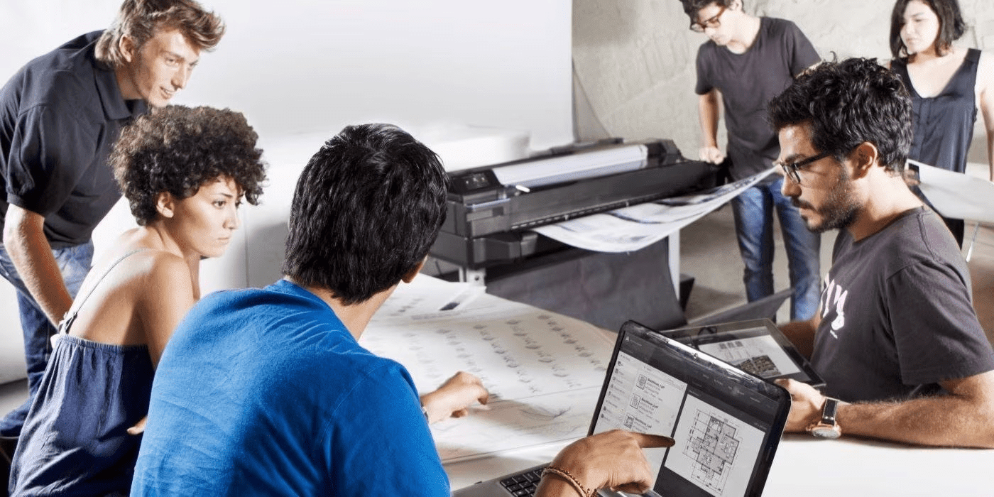 Persona trabajando en un ecosistema HP: Workstation mobil + Monitores duales HP.