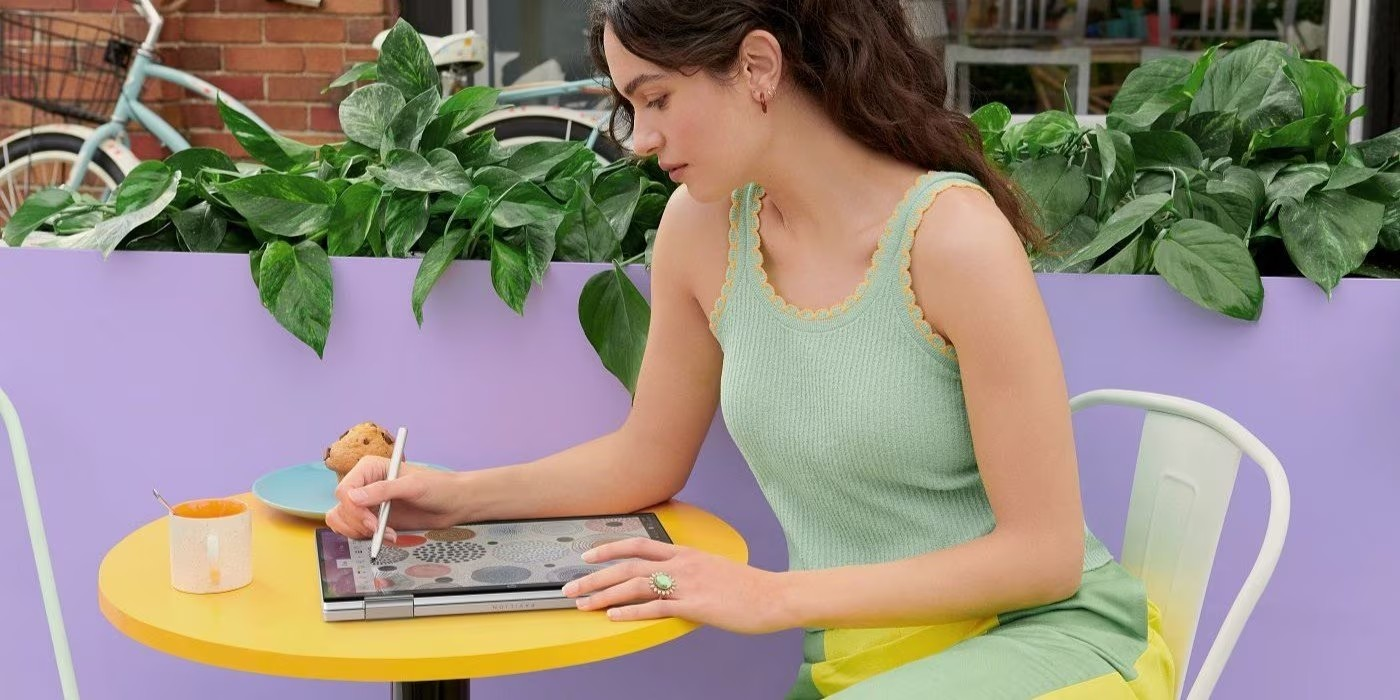 Mujer trabajndo de forma reomta en diseño gráfico, usando una laptop convertible HP.