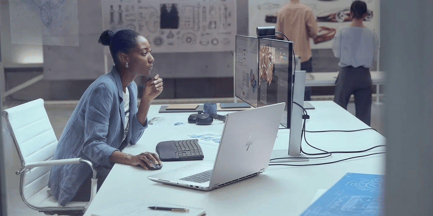 Mujer trabajando en su oficina en una Workstation HP y monitores externos